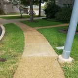 Clean concrete walkway beside a lawn